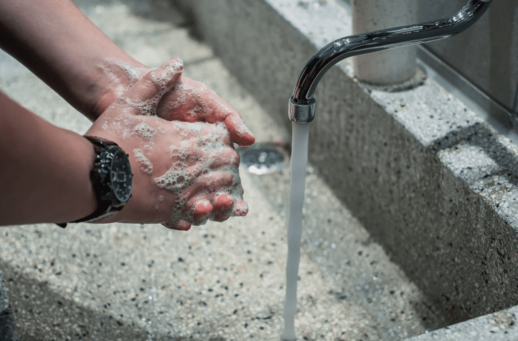 Handwashing with soap at an outdoor event hygiene station