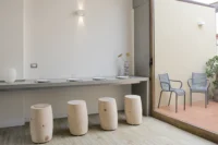 The counter and log stools beside the full-height window that opens onto the terrace at Space is Luxury in Taormina
