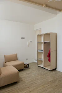 Beige modular sofa and two plywood wardrobe units on castors in the living area of Space is Luxury