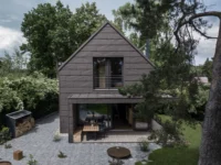 Aerial view of the Cottage terrace, with the covered outdoor seating, timber deck and a circular fire bowl set into the stone paving