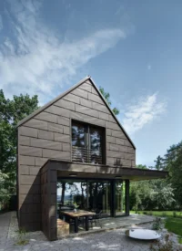 The Cottage at the end of the terrace, with the timber-lined loggia open to the garden and a fire bowl on the paving