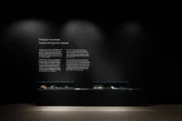 Voyagers through the Universe room at Dinosauria Museum Prague, with bilingual Czech and English wall text above two low mineral display cases