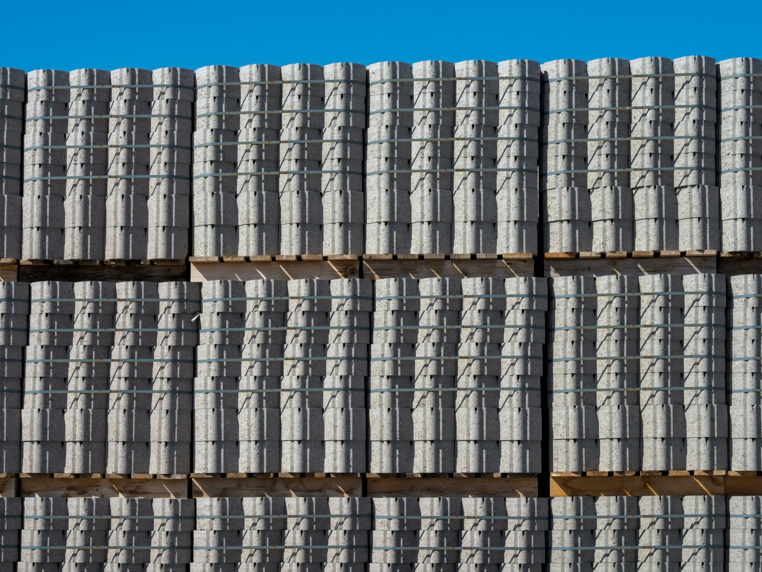 Pallets of concrete pavers stacked before a patio installation