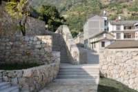 Stair rising between stone walls toward the village houses at Bawan Village Visitor Center