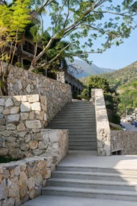 Stepped route between stone retaining walls at Bawan Village Visitor Center by TAO