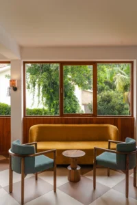 Yellow sofa and blue armchairs in a corner lounge at Celine and Lolo Hotel