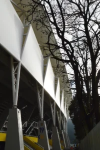 The facade envelope seen through the trees, Ester Roa Rebolledo Municipal Stadium