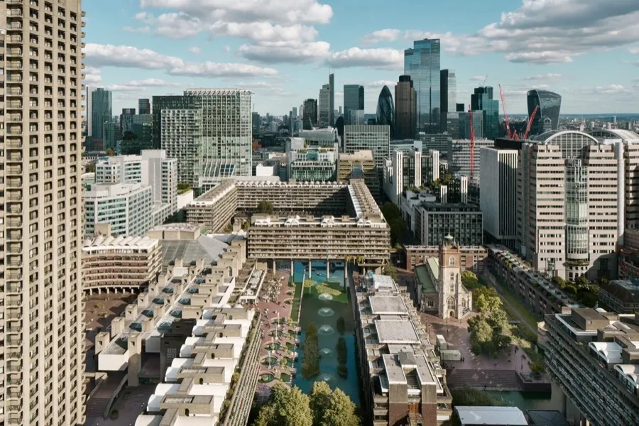 Aerial view of the Barbican estate with its terraced concrete blocks, lake and the City of London skyline