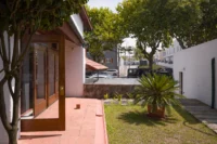 Courtyard and garden with mature planting beside the house, Casa d’Abreu Neto by Álvaro Siza