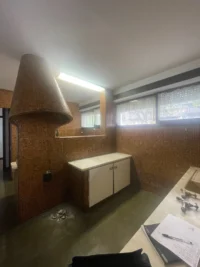 Kitchen before the reactivation, with the cork hood and stripped cabinets, Casa d’Abreu Neto by Álvaro Siza