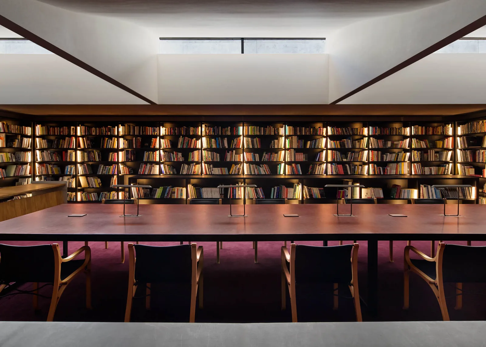 Library and bookshop interior with timber shelving and reading tables at CCA Tashkent
