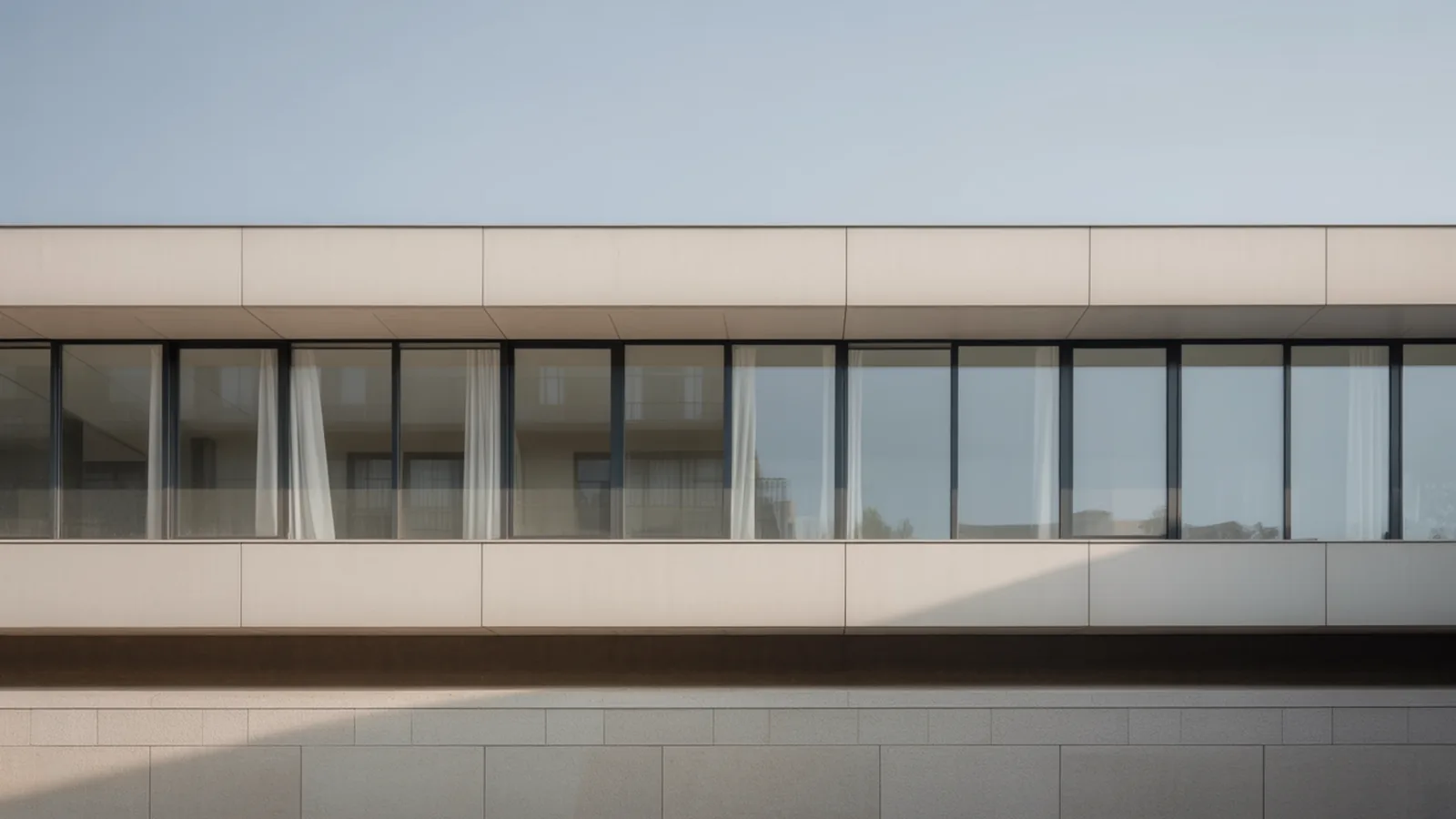 Modernist facade with a long uninterrupted ribbon window and smooth white render above and below
