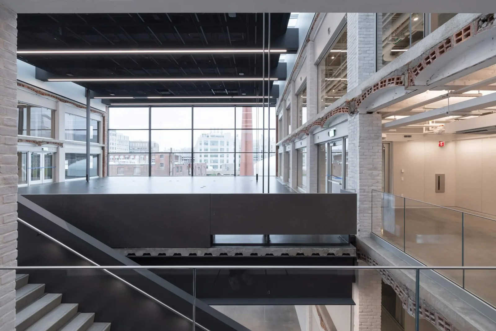 Interior of the converted Metropolitan Warehouse at MIT with exposed brick piers and open studio floors