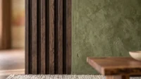 Dark timber slatted panelling meeting an olive plaster wall