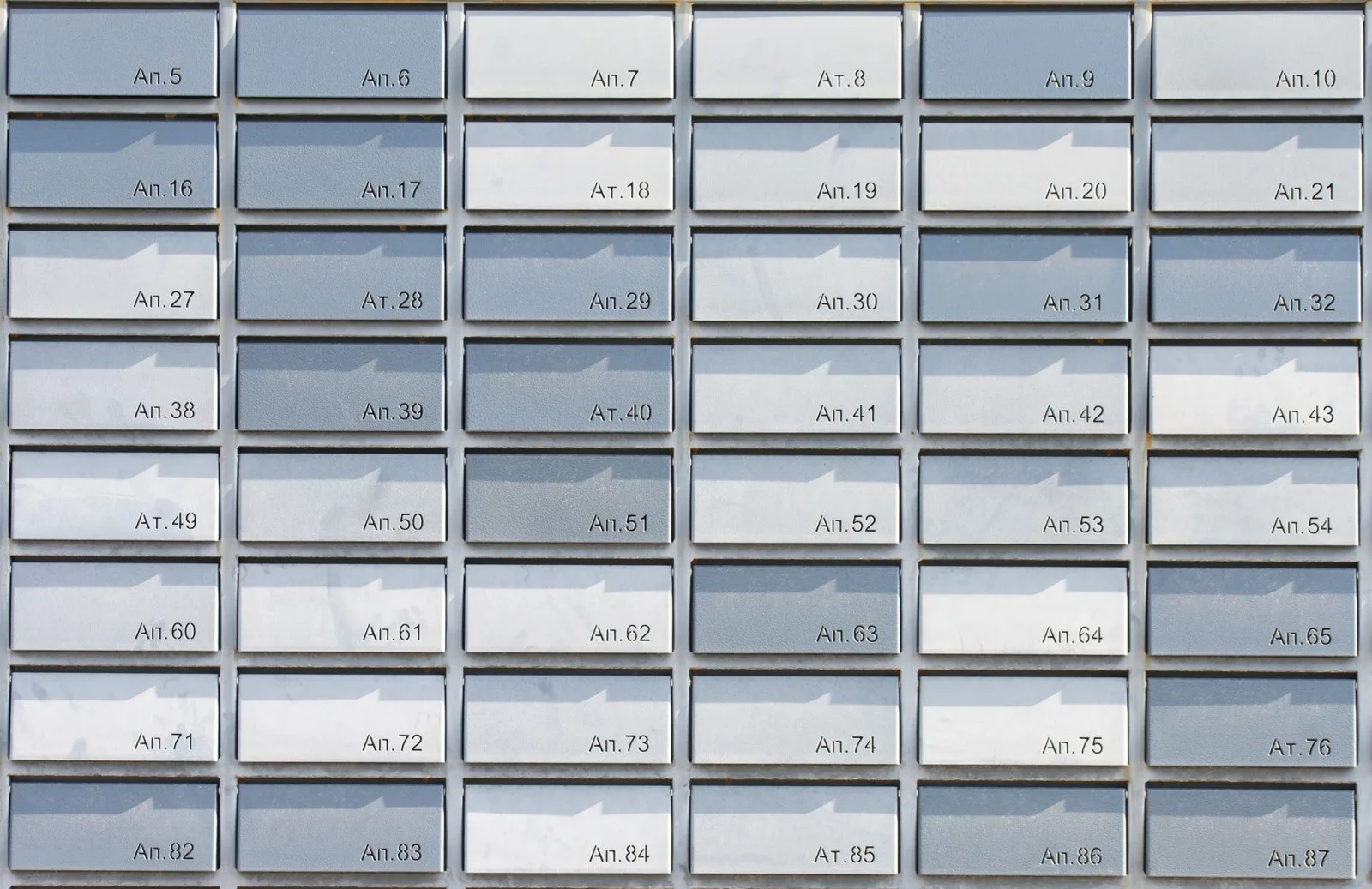 Grid of numbered metal mailboxes in an apartment building lobby