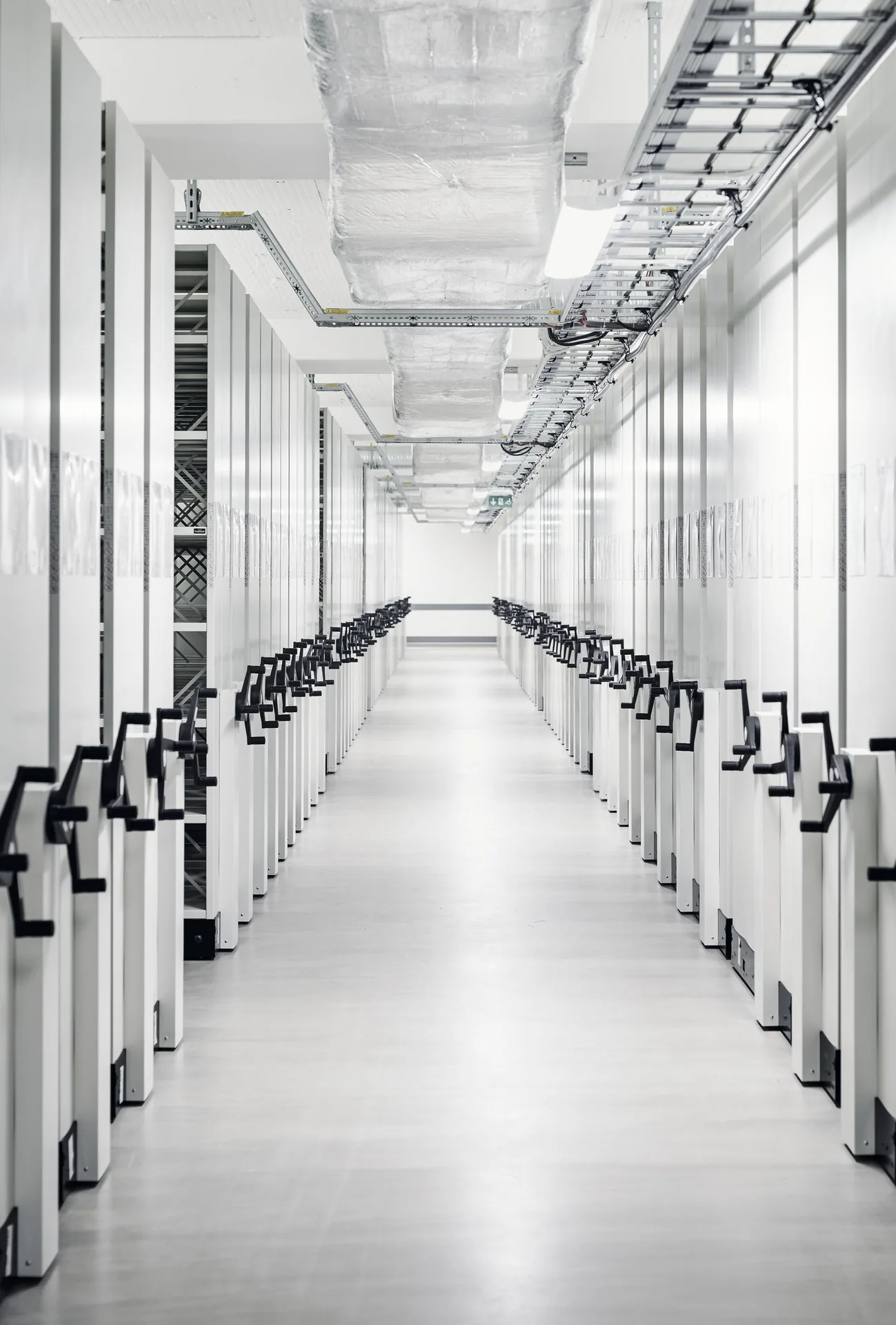 Aisle of rolling archive shelving at National Archives of Sweden by Tengbom