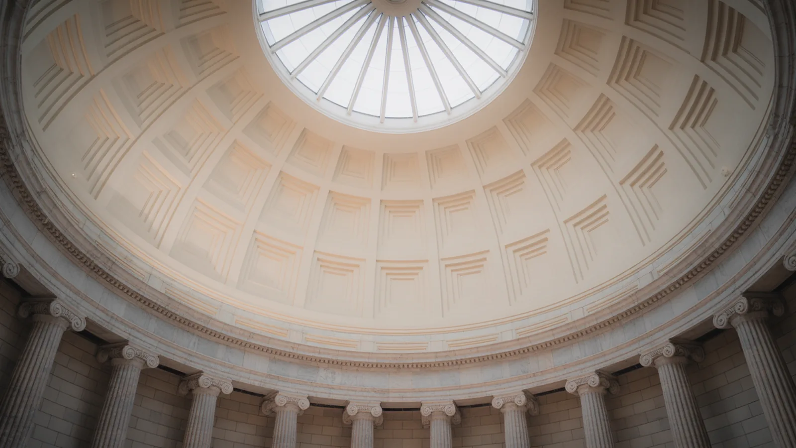 Neoclassical rotunda with coffered dome, ring of columns and a central oculus admitting daylight