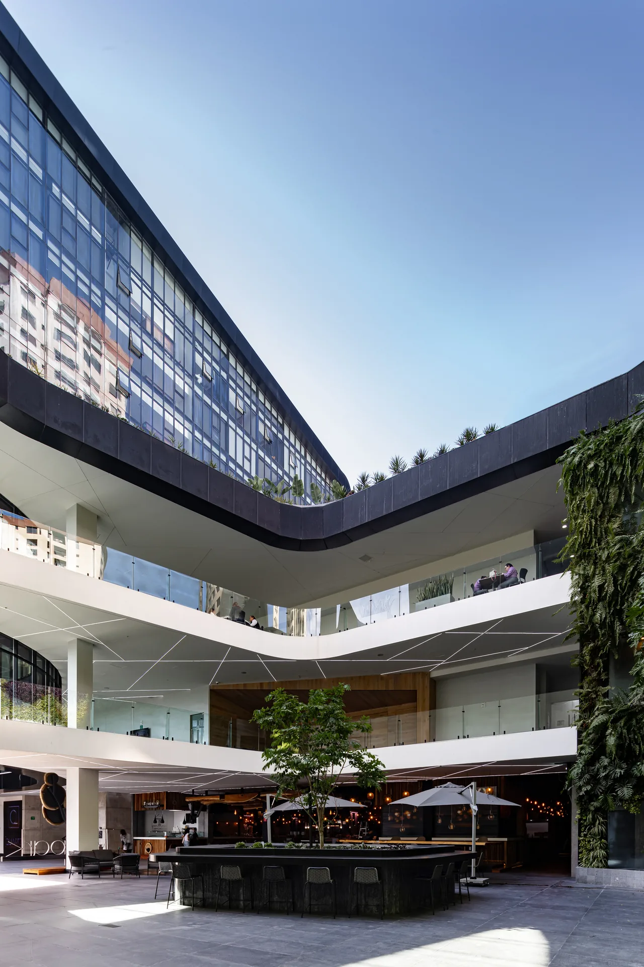 The raised commercial plaza inside New City Medical Plaza by CRAFT Arquitectos