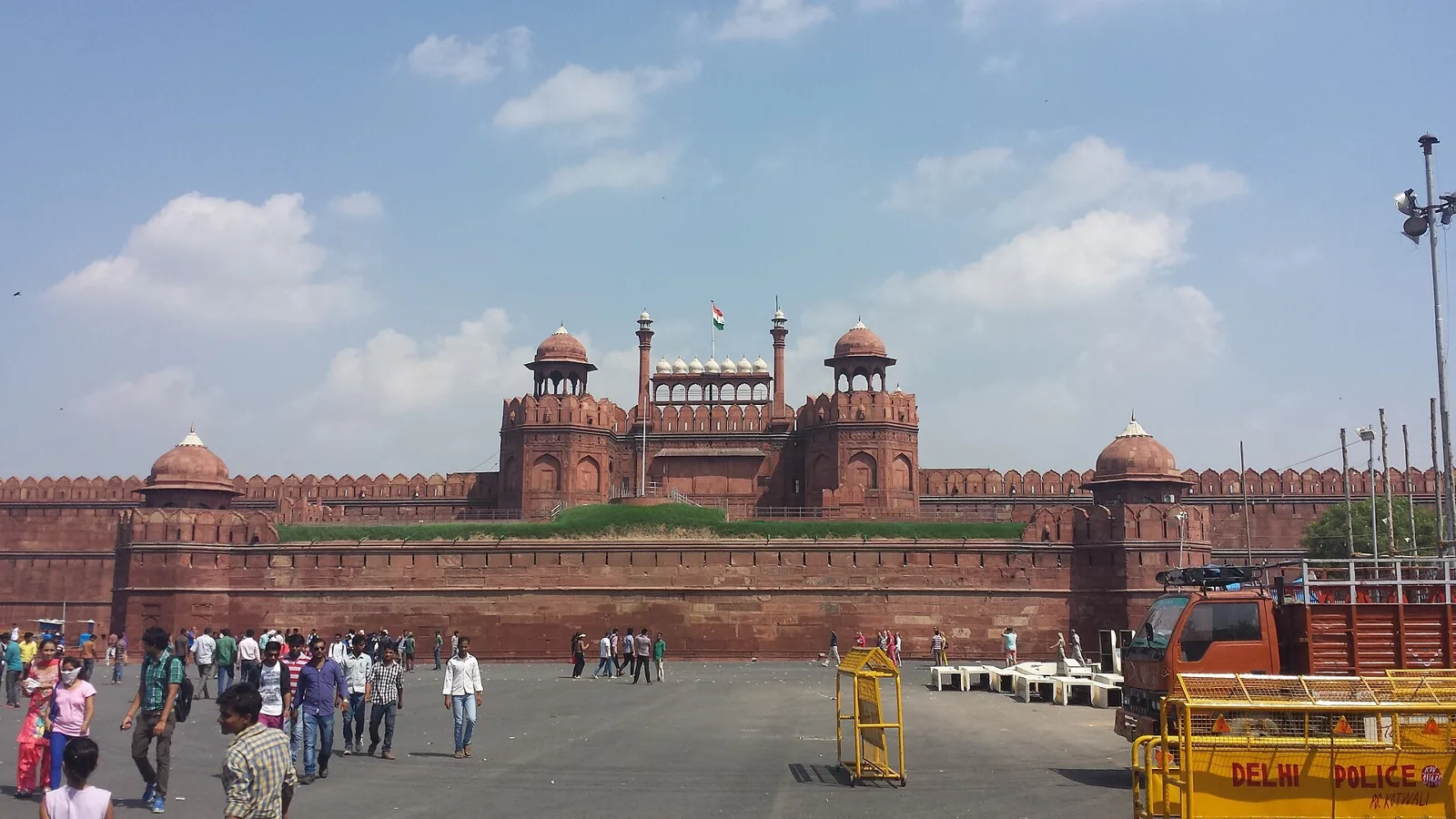 Red sandstone walls and the Lahori Gate of the Red Fort in Delhi with visitors in the forecourt