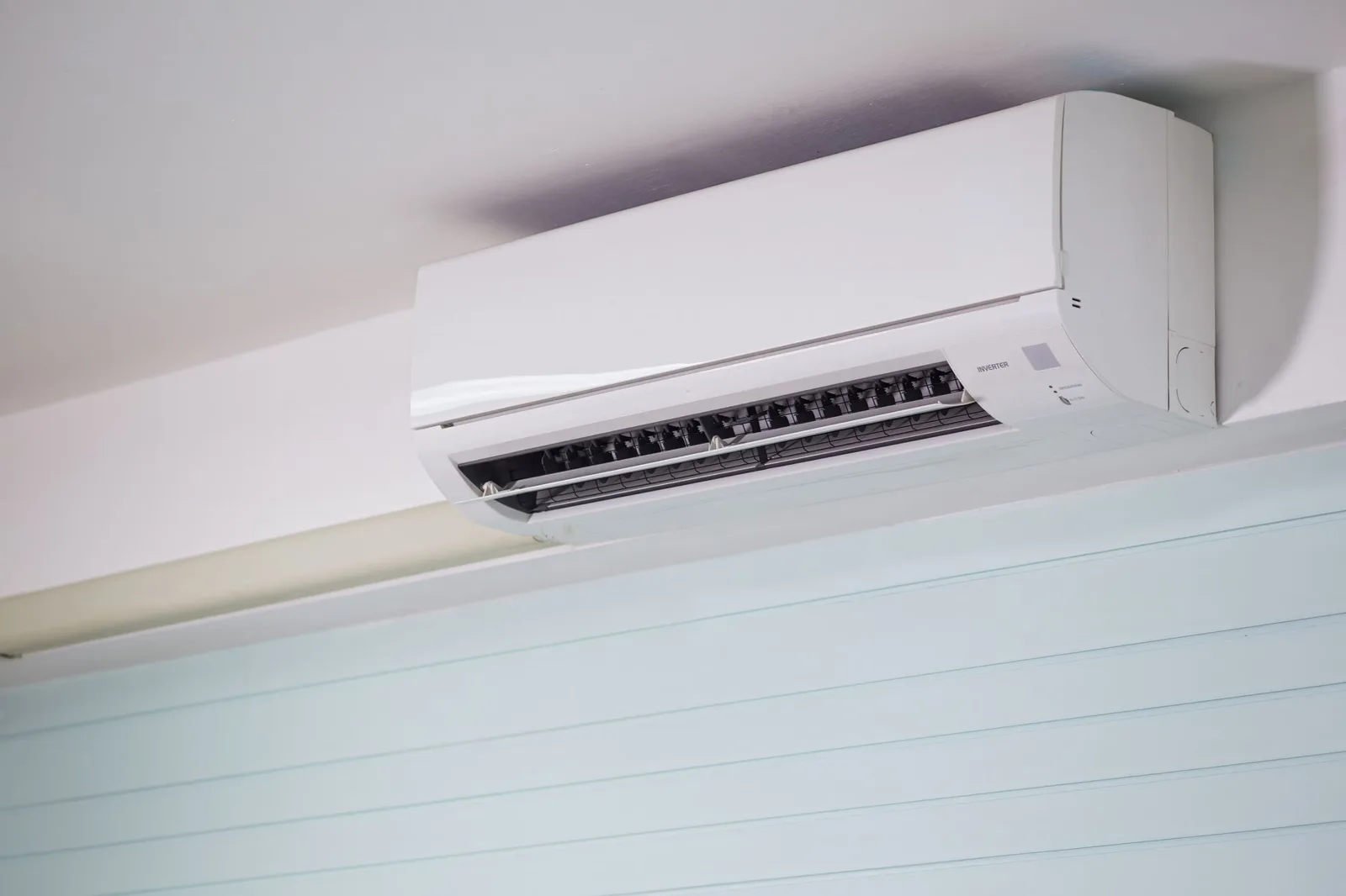 Wall mounted mini split indoor unit fitted high on a wall below the ceiling
