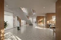 Bright interior hall with terrazzo floor, timber panelling and a sculptural stair, Zašová Health Center by AOSI