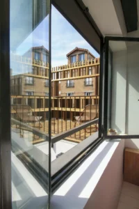 The new window seen from inside the house, opening onto the timber terrace, Inhabiting the Roof by Paris Atlas