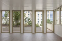 Interior room with full height windows opening onto planters and young trees, Mokuzai by IT'S Architecture
