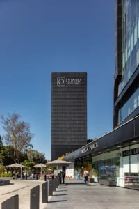 Shops and umbrellas on the plaza of New City Medical Plaza by CRAFT Arquitectos