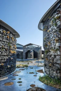 Gabion walls and planting around a courtyard pond, Future Life Village Pavilion