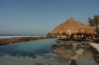 The lagoon pool and palapa at Rosa Jamaica Beach Club by Gris Estudio