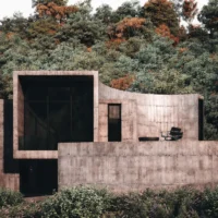 Rendering of a concrete elevation with a small terrace opening toward the trees, Savan House by Nobico Studio