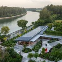 Aerial view of a long pitched roof pavilion and plaza beside the Serangoon Reservoir, Singapore Institute of Technology by Henning Larsen