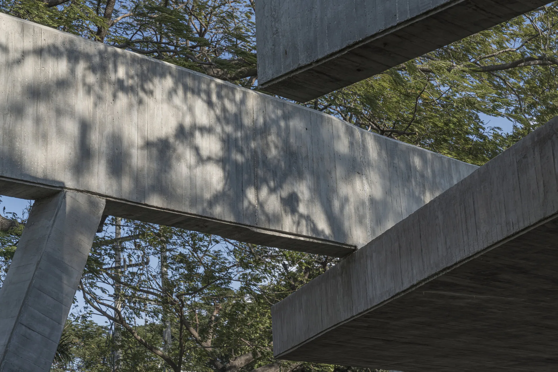 Concrete beams crossing overhead at Student Center Santa Marta