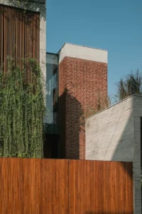 Teak slats in a concrete-bordered box on the office elevation, The House of Memories
