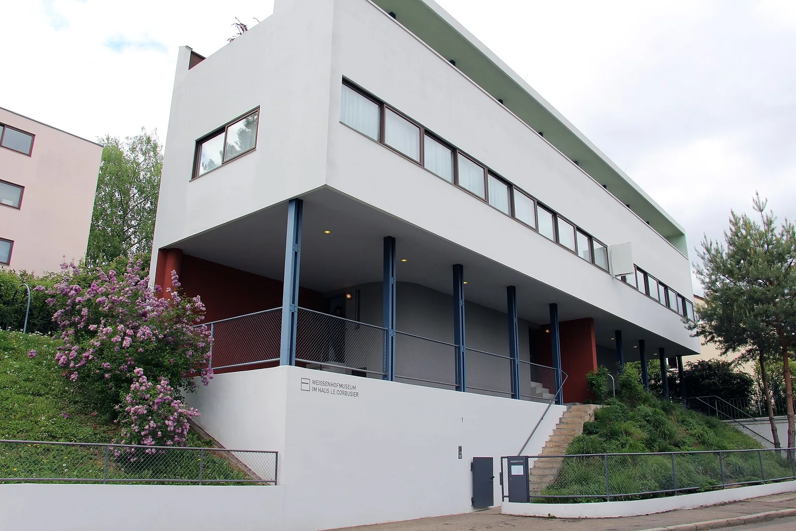 White Le Corbusier double house at the Weissenhof Estate in Stuttgart, with ribbon windows raised on slender blue columns