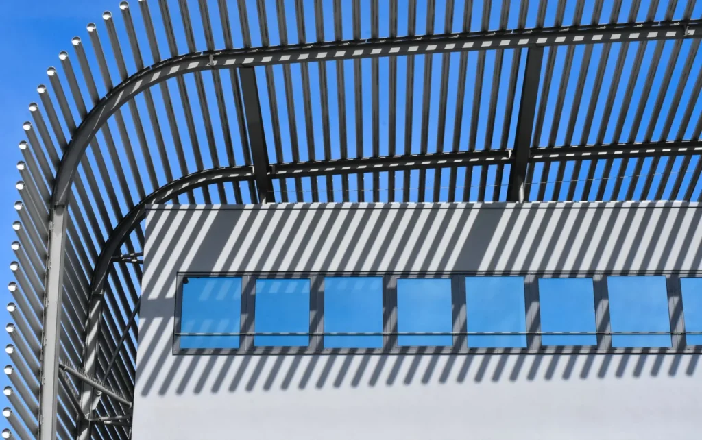 Curved metal sun-shading louvres projecting over a row of windows