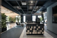 Coffee counter clad in blue and cream tiles under an open black ceiling grid, ADDITIVE HQ by NOA