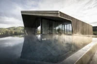 Steaming infinity pool reflecting the timber clad spa wing at the edge of the meadow, Aeon by noa*