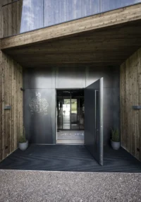 Entrance portal of black steel with the family coat of arms, set into the timber facade, Aeon by noa*