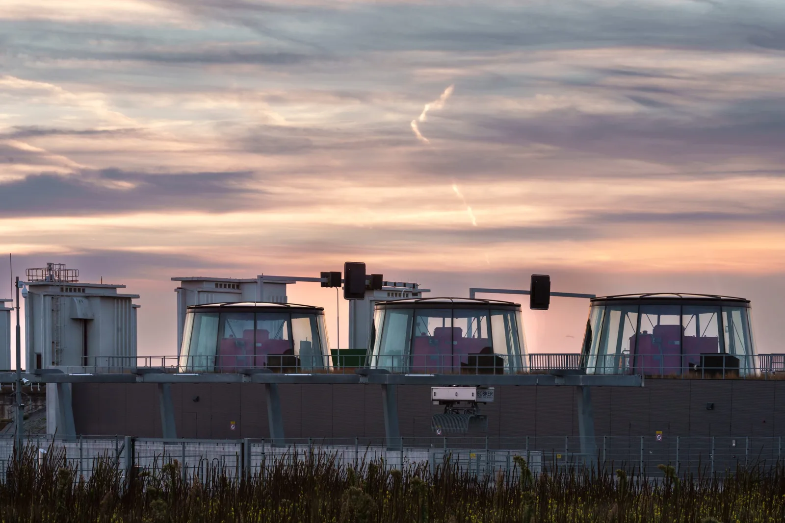 Row of low glazed domes housing pumping stations on the dam at dusk