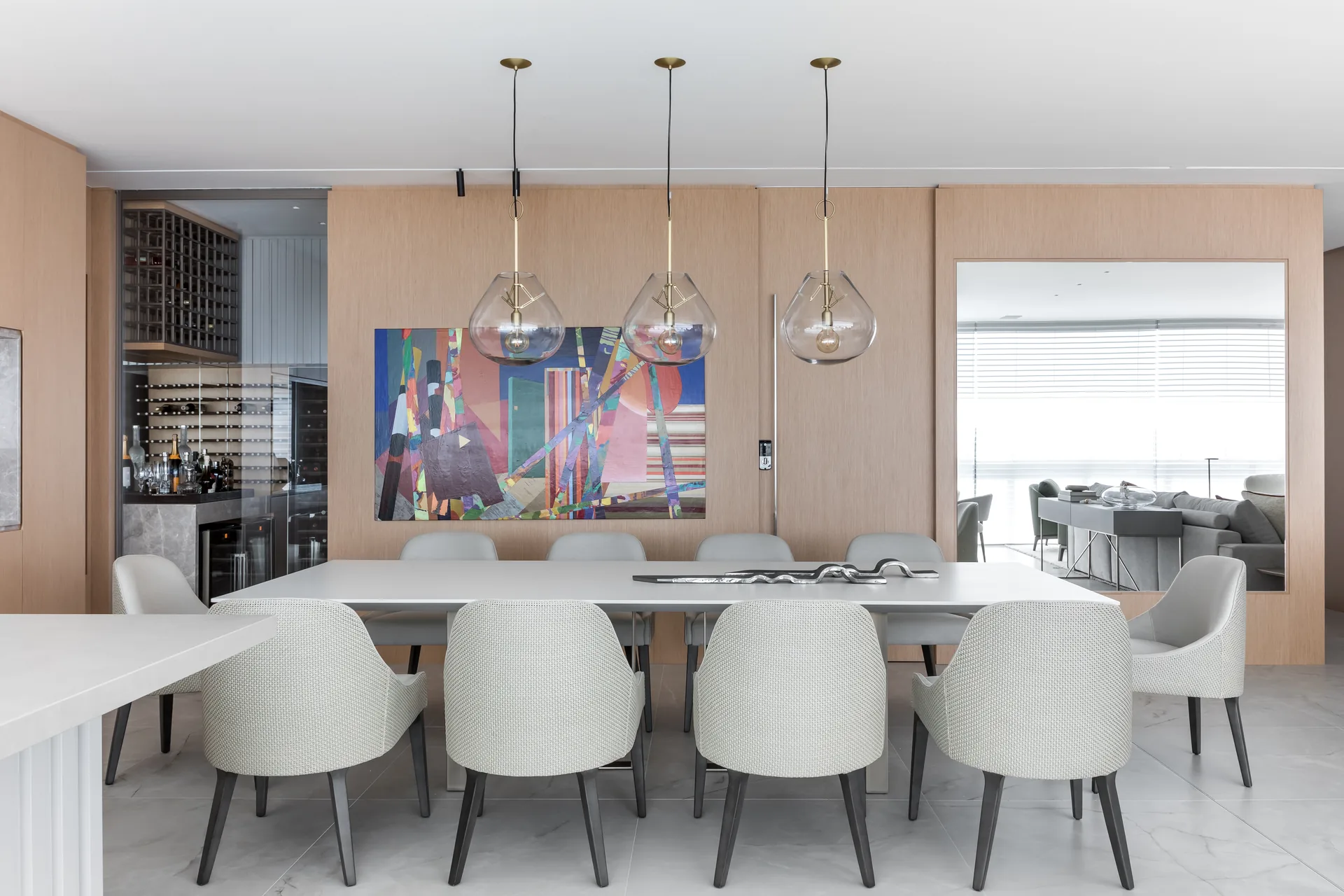White dining table and pale chairs under glass pendants, Apartment Elache by Caroline Andrusko Arquitetos