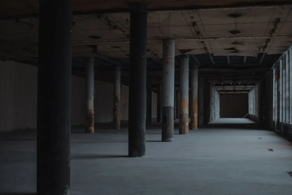Empty concrete hall with rows of evenly spaced columns, showing the structural grid in architecture