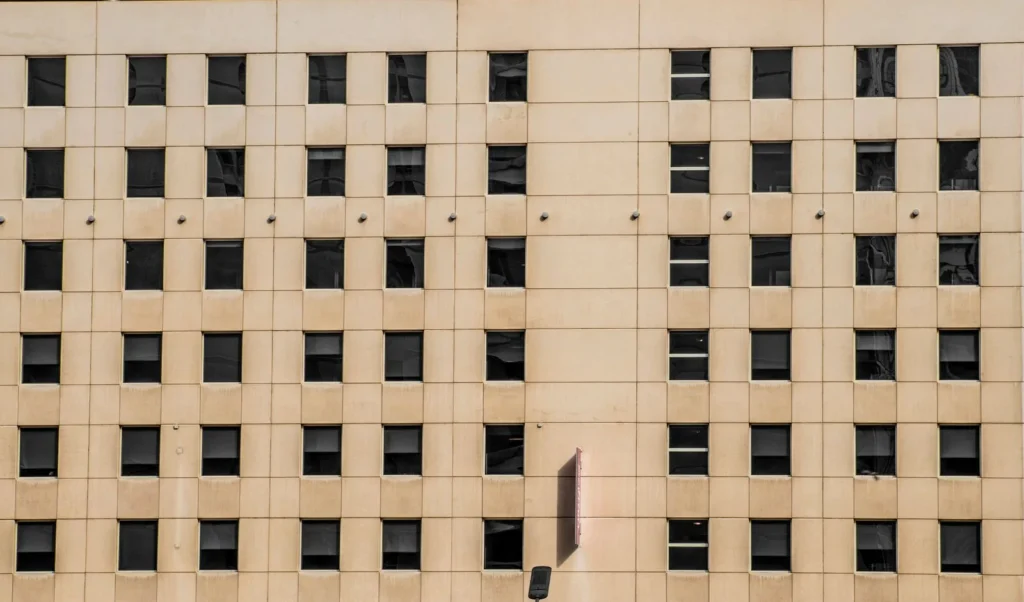 Beige office facade with square windows set in a strict repeating pattern