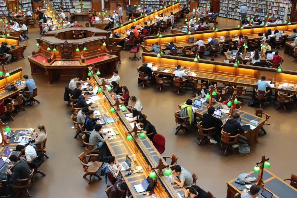 High angle view of a large university library reading room filled with students at desks