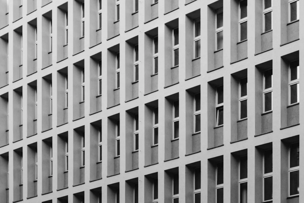 Grid of identical vertical window bays setting a steady rhythm across a modernist facade