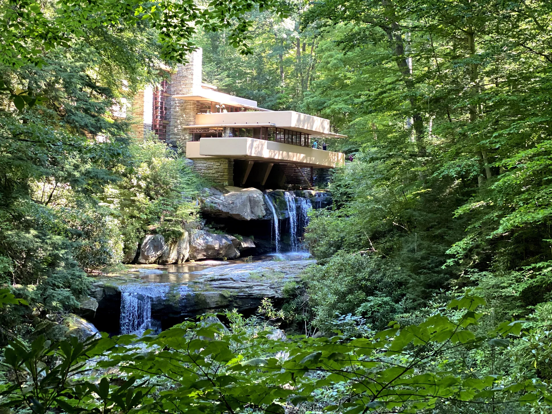 Fallingwater by Frank Lloyd Wright, cantilevered concrete terraces stacked over a waterfall in the woods