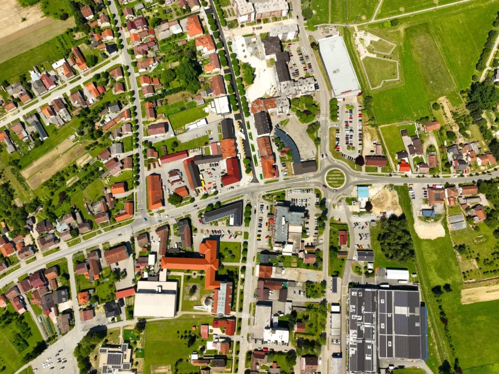 Top-down aerial view of a small town showing streets, a roundabout, houses and fields