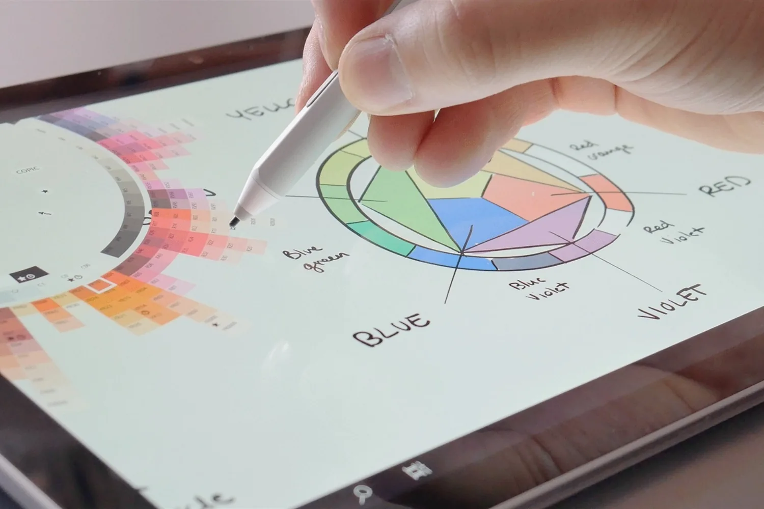 Stylus drawing a color wheel diagram in the Concepts app on a tablet with the COPIC color picker open