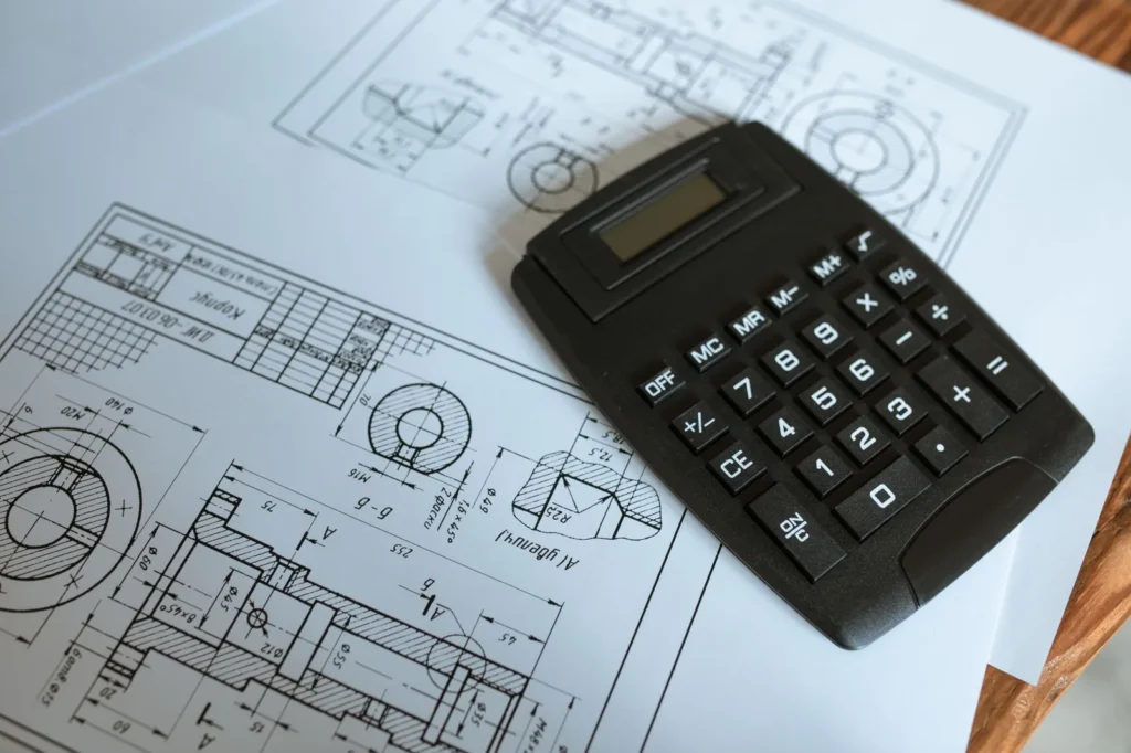 Calculator resting on printed technical drawings, a tool of construction budget management
