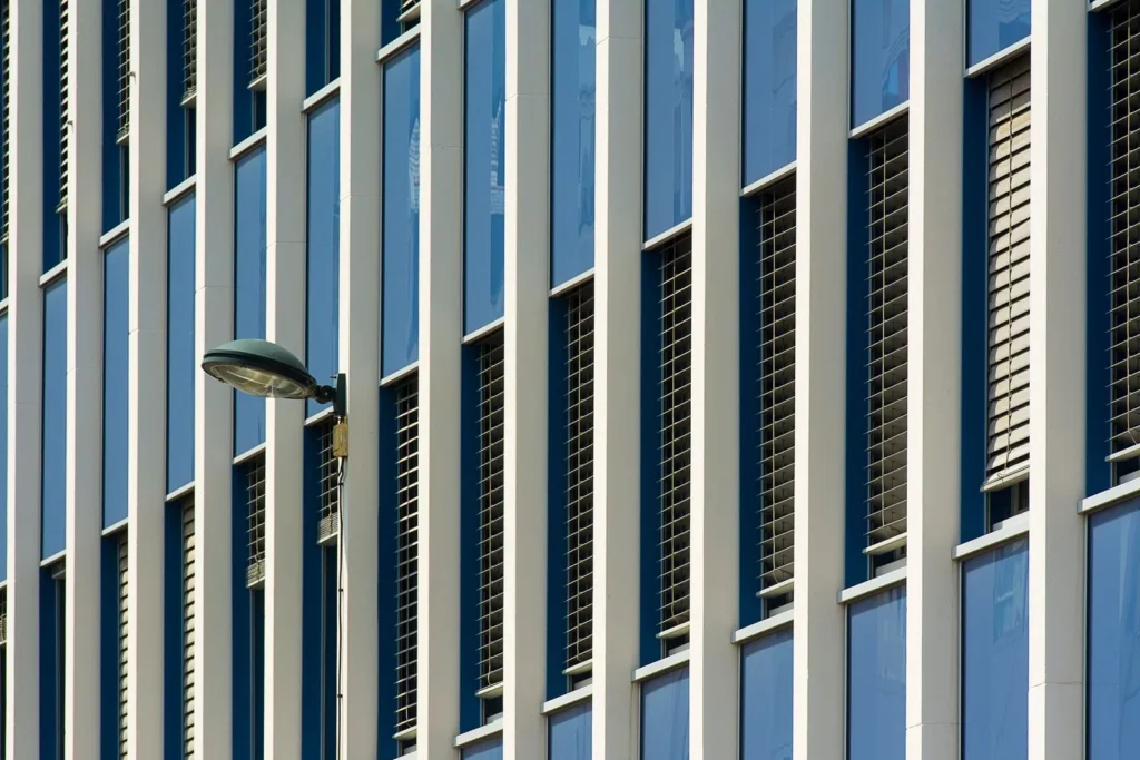 Vertical fins set in front of blue-framed windows to shade the glazing on an office facade